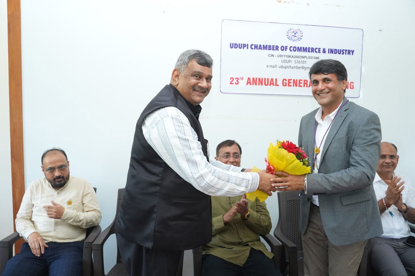 Outgoing President greets the new President at the AGM